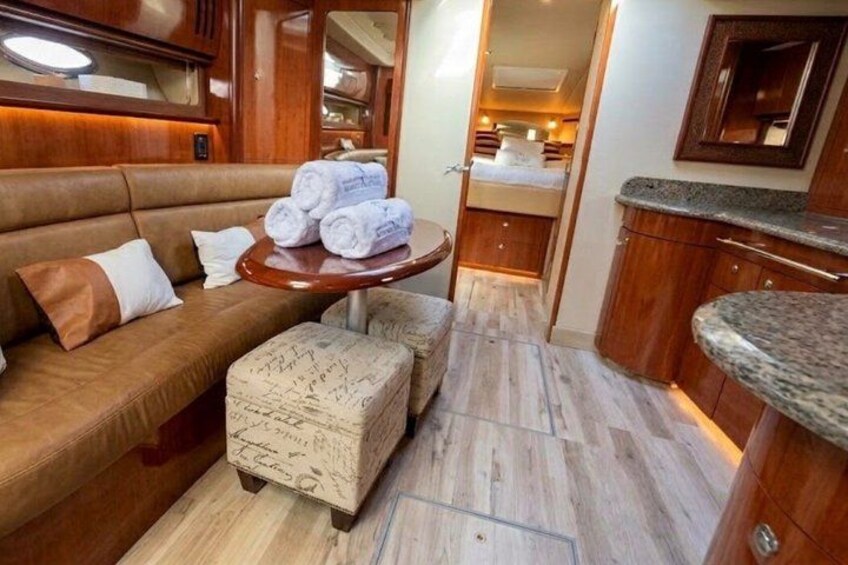 A cozy interior with a brown sofa, a small round table with towels, and a wooden cabinet. 4