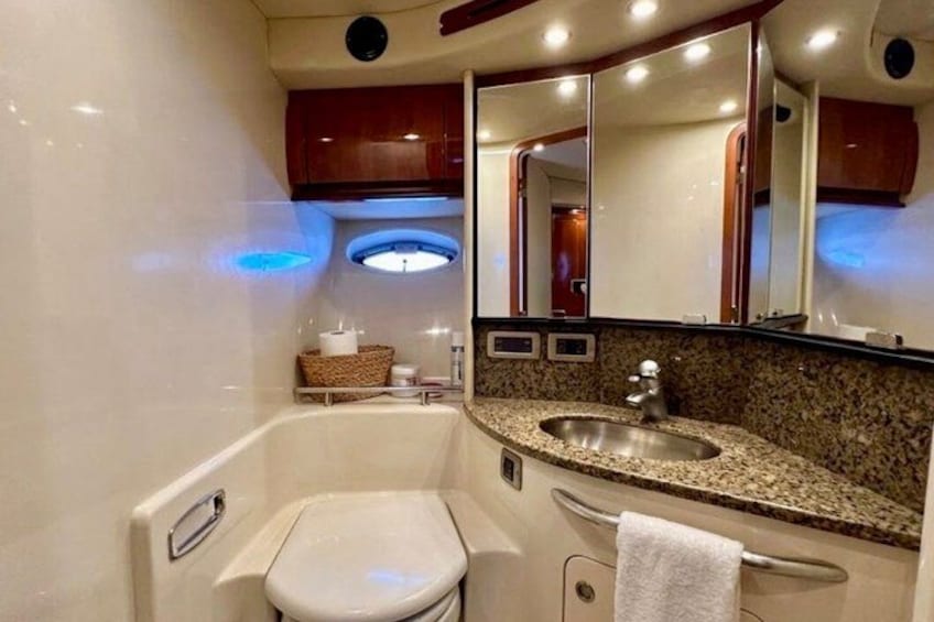 A bathroom with a white toilet, a sink, and a mirror. 2