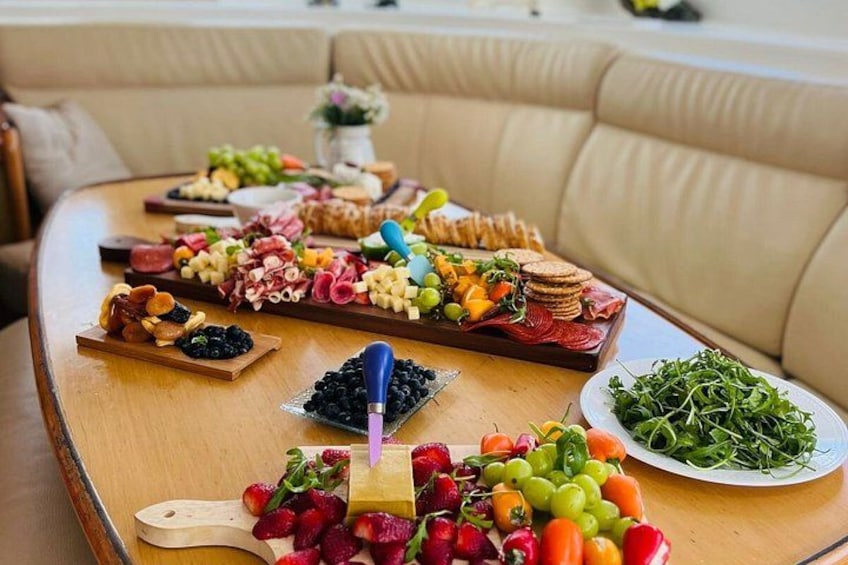 Un tavolo di legno con diversi cibi, tra cui frutta, formaggi e cracker. 5