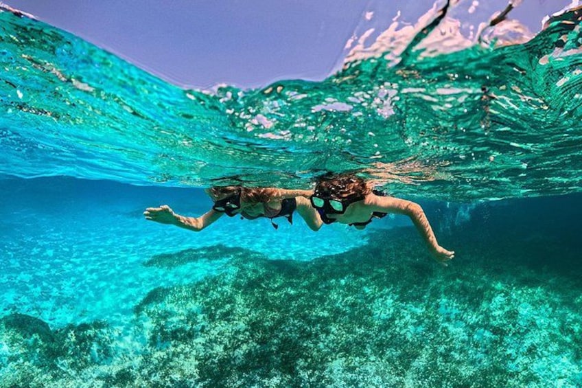 Una persona nadando bajo el agua en aguas azules y cristalinas. 4