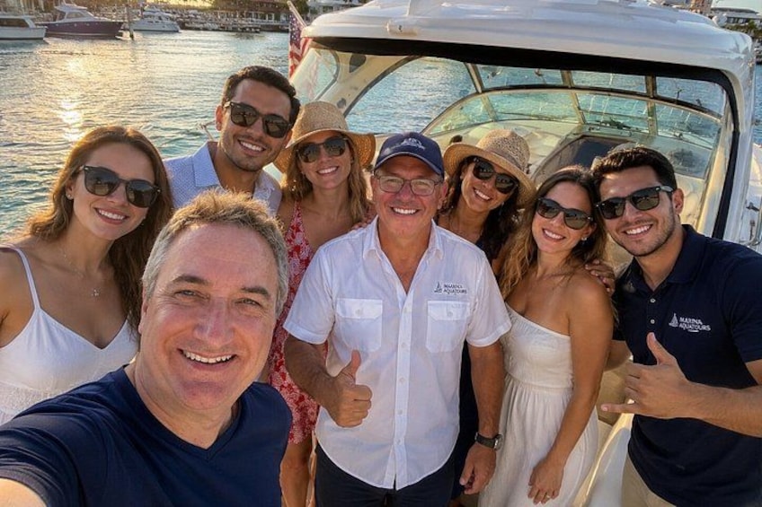 Un gruppo di persone su una barca, con uno sfondo che mostra un porto turistico. 3