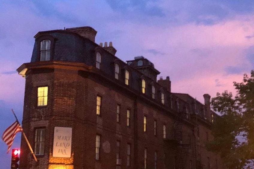 A historic brick building with a sign reading 'Mary Land Inn' at dusk. 3