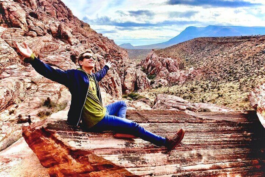 A person sitting on a wooden bridge in a rocky desert landscape. 1
