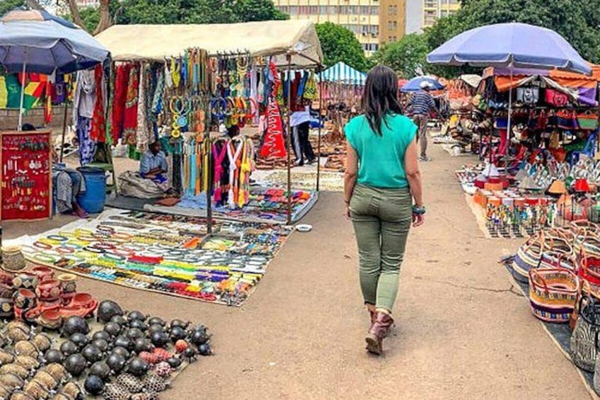 Ein Markt mit verschiedenen Ständen, auf denen bunte Textilien und Accessoires verkauft werden. 2