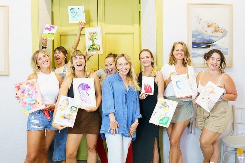 A group of people holding up colorful drawings. 3