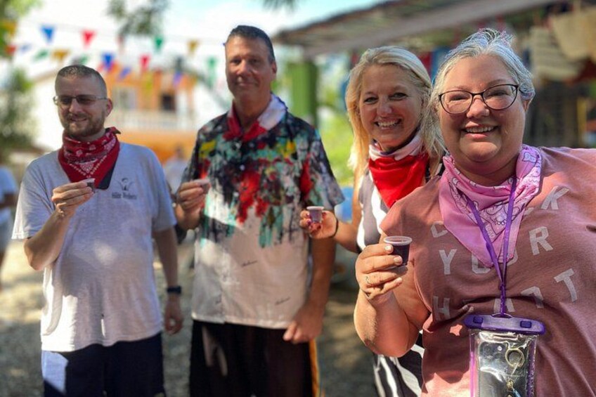 People walking outdoors, some holding drinks, with colorful flags in the background. 2