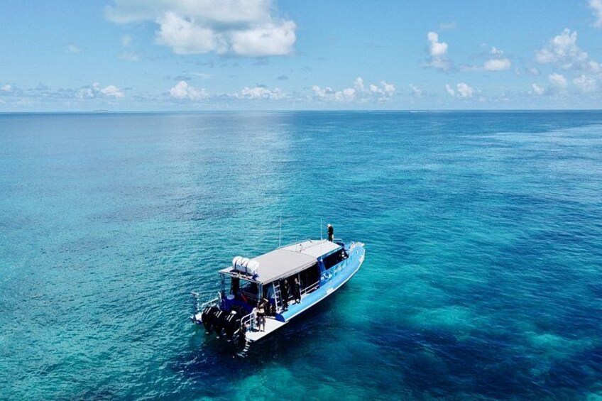 A boat on clear turquoise water with a clear sky. 2