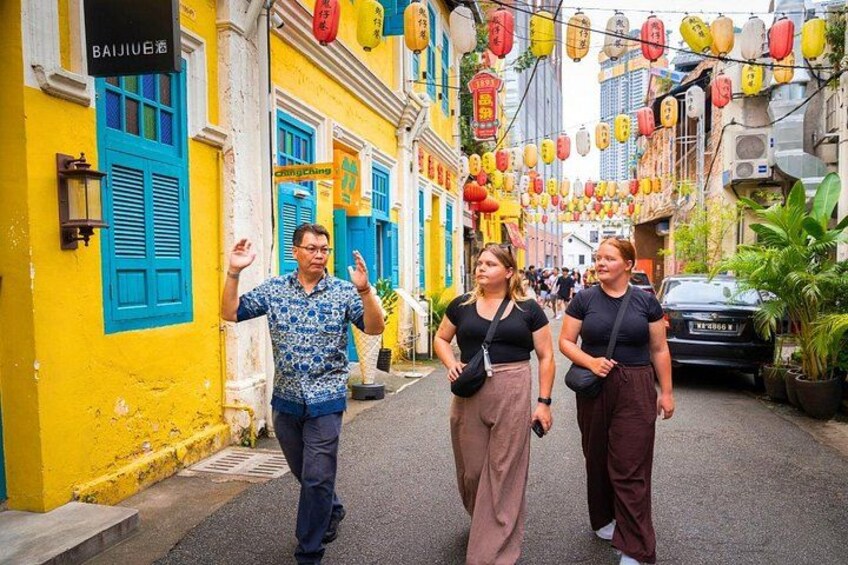 A street with colorful buildings, a man gesturing, and two women walking. 2