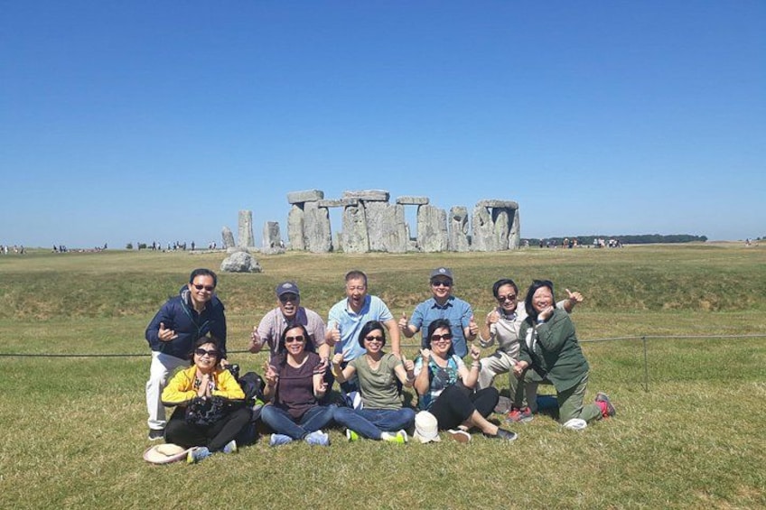 En gruppe mennesker poserer foran Stonehenge. 1