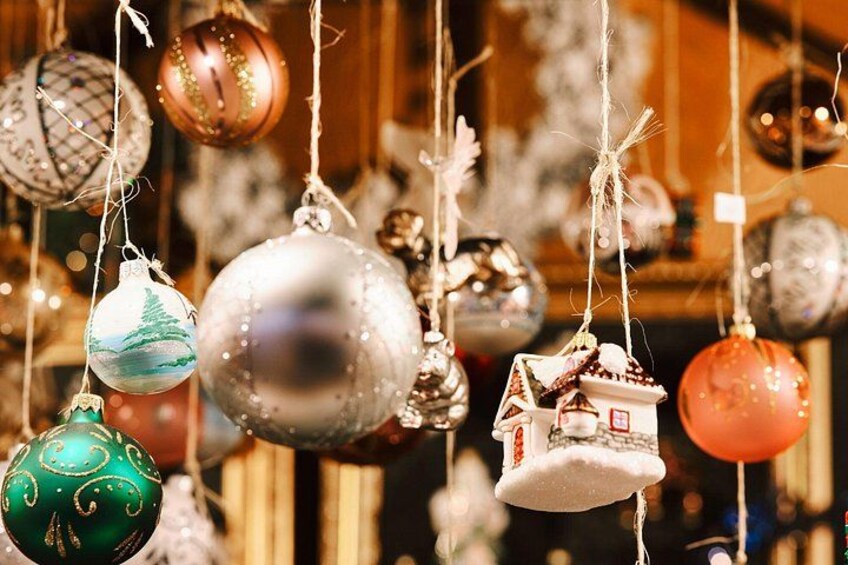 Various Christmas ornaments hanging, including a house-shaped ornament and a silver ball ornament. 2