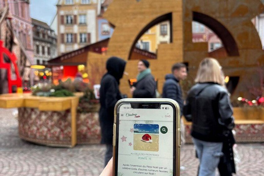 A smartphone displaying a map with a location pin, a red circular object, and text in a foreign language. 1