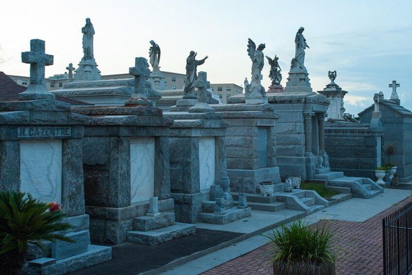 A cemetery with stone headstones and statues. 5