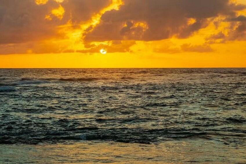 A sunset over the ocean with waves and a clear sky. 2