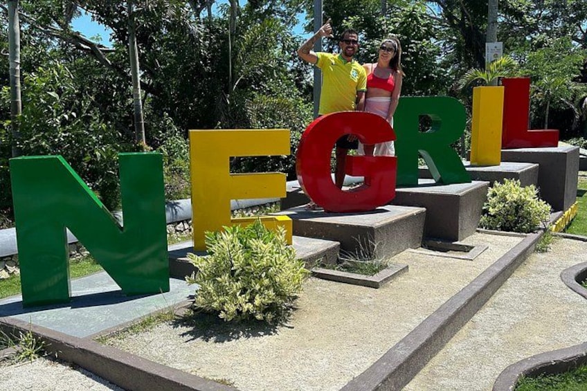 Large colorful letters spelling 'NEGRL' with people standing in front. 4