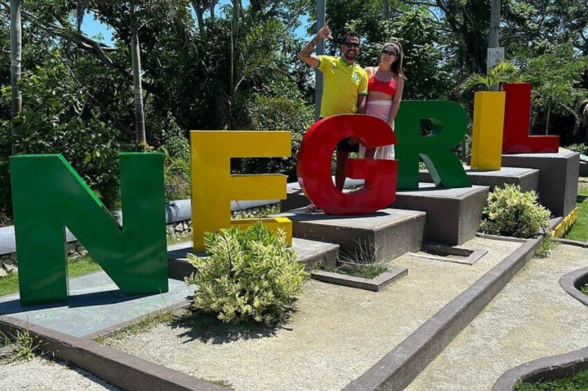 Large letters spelling 'NEGRIL' with people standing on them. 5