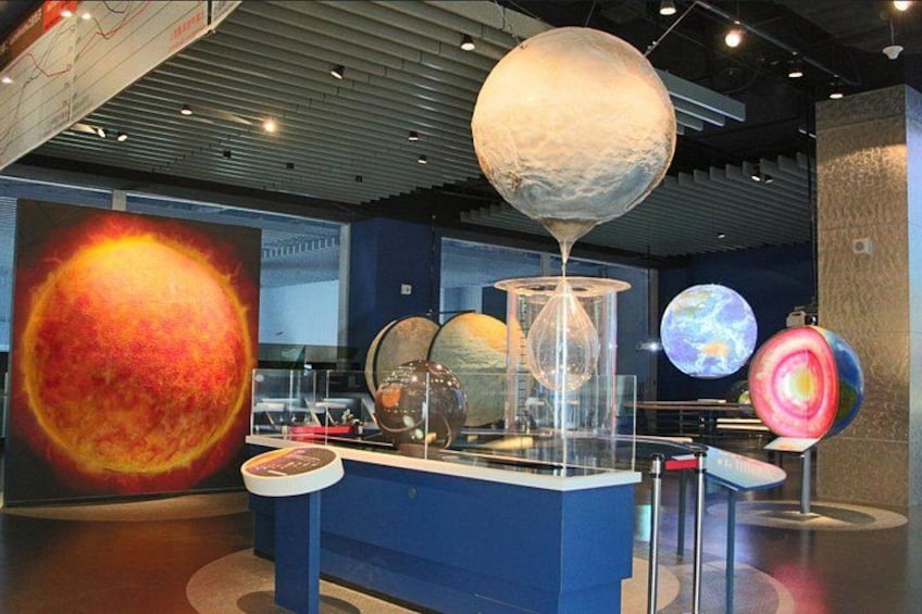 En museiutställning med en stor presentation av planeter och en glaskula. 4