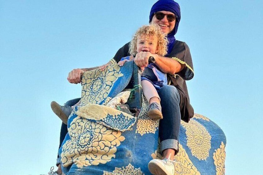 A person riding an elephant with a child. 2