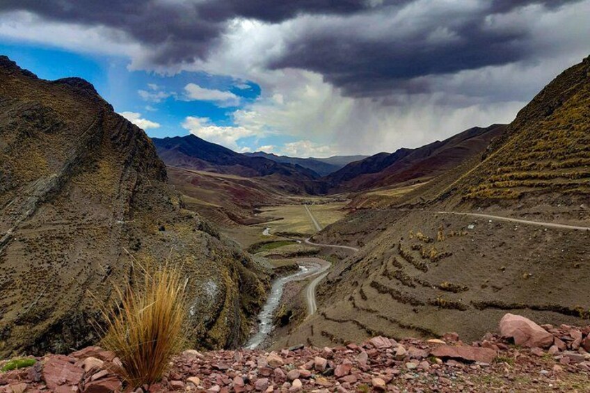 Une rivière sinueuse traverse une vallée montagneuse, caractérisée par un terrain rocheux et une végétation clairsemée. 3