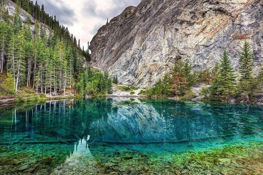Un lac aux eaux limpides, entouré d’une forêt dense et de montagnes rocheuses. 4