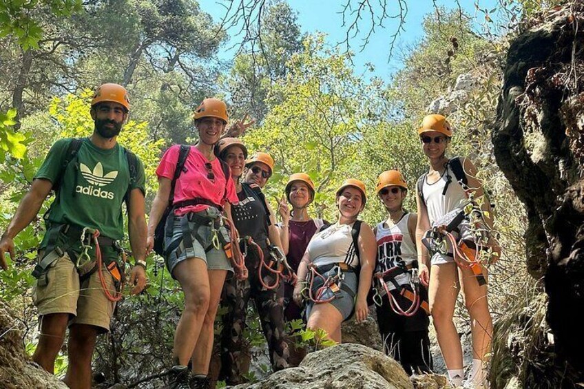 A group of people hiking in a forested area with rocky terrain. 4