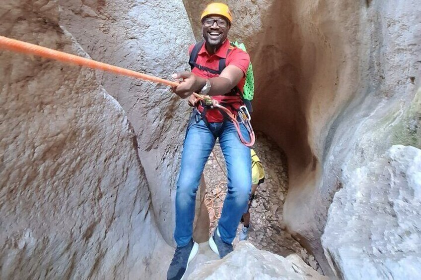 A person rappelling down a rocky cliff. 1