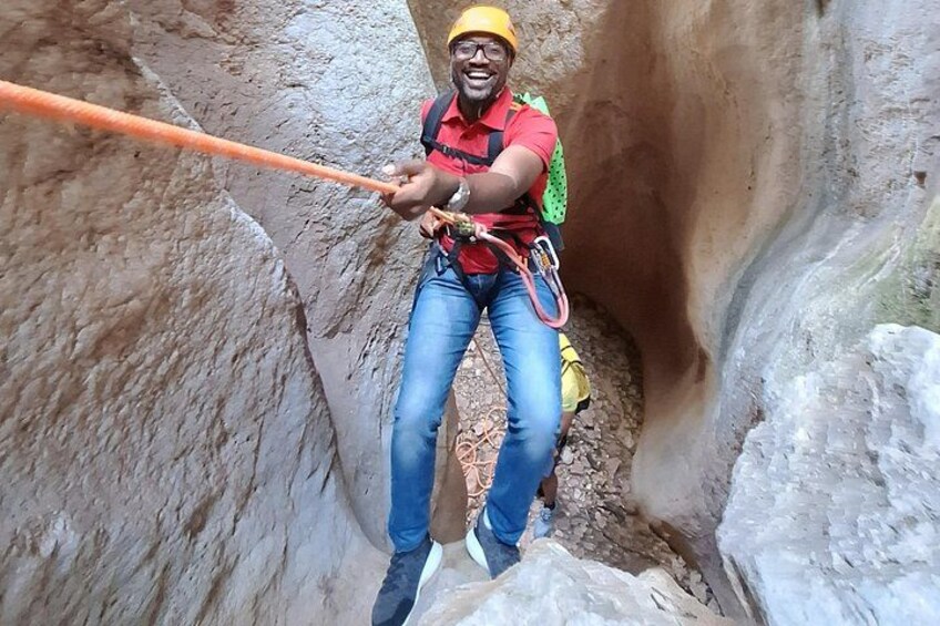A person rappelling down a rocky cliff. 3