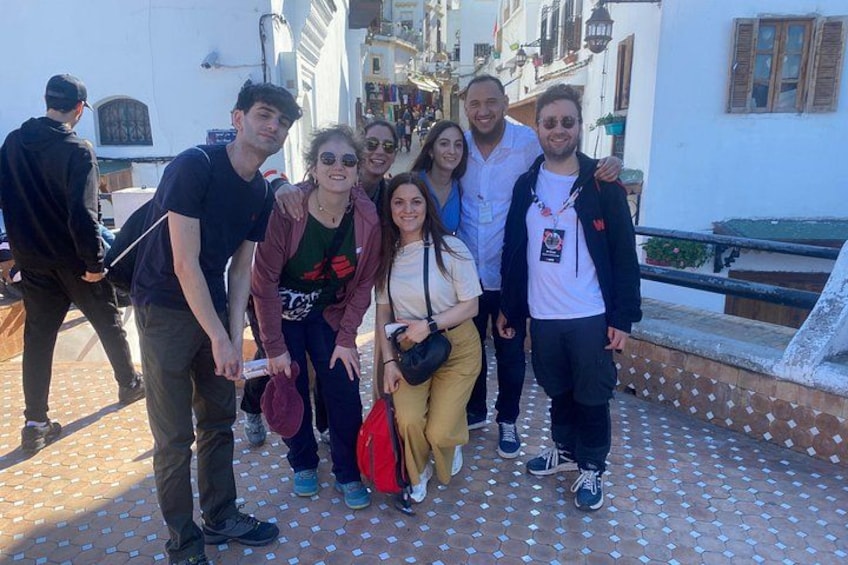 Un grupo de personas de pie sobre un camino empedrado con edificios al fondo. 2
