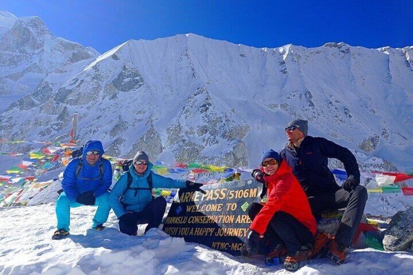 Een groep mensen bij een bergpas, met een bord waarop staat dat de pas 5106 meter hoog is. 1