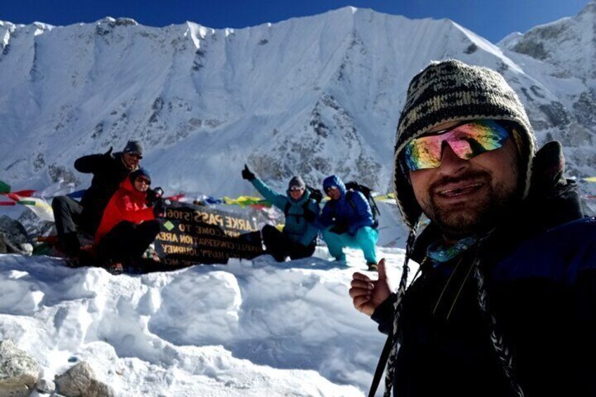 Een groep mensen op een besneeuwde berg, met een bord op de achtergrond. 2