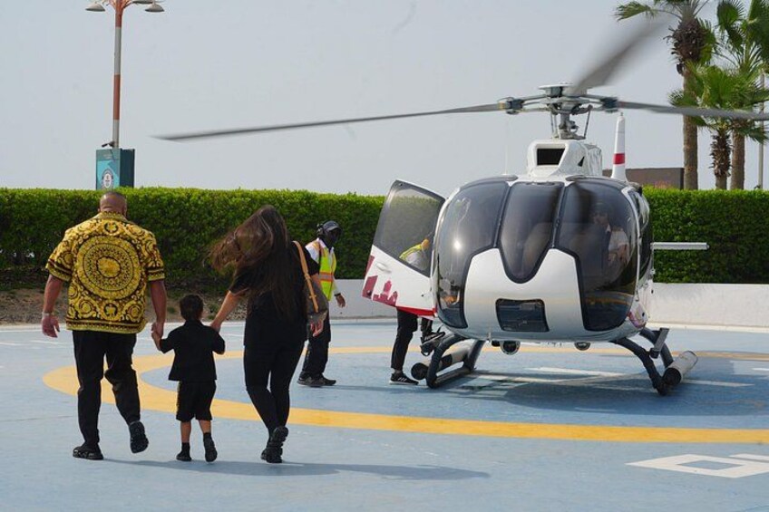 A helicopter, people walking, and a palm tree. 1