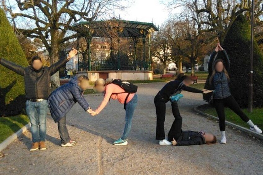 A group of people in a park, one person lying on the ground, others standing around. 2