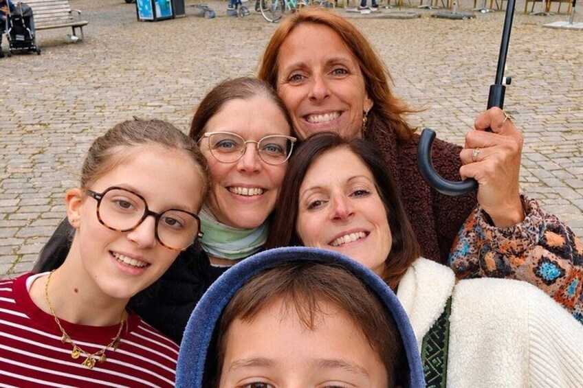 Een groep mensen maakt een selfie in een openluchtomgeving met kinderaardewegen. 4