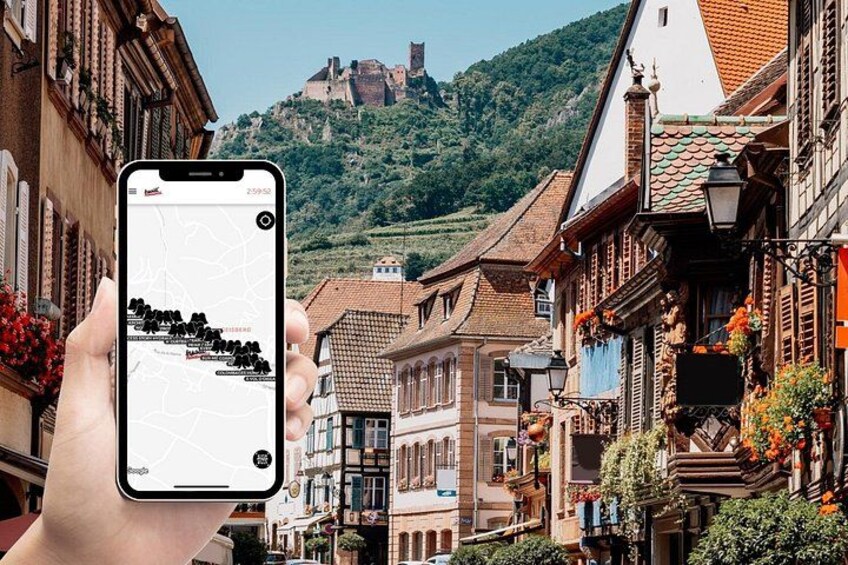 Ein Smartphone zeigt eine Karte mit Bergen und Gebäuden im Hintergrund. 1