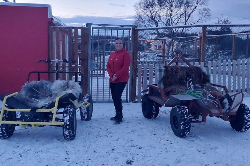 A person standing between two snow vehicles in a snowy outdoor area. 2