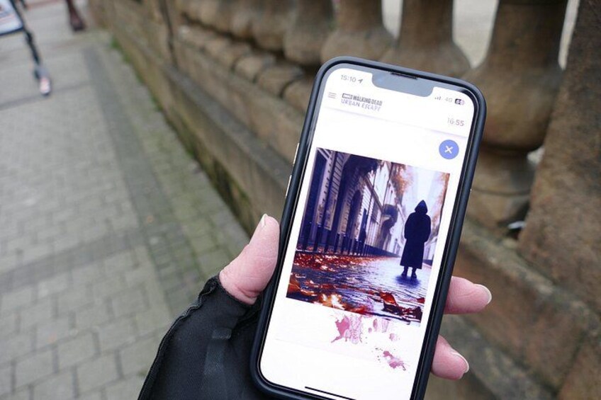 A smartphone displaying a photo of a person walking on a wet pavement. 2