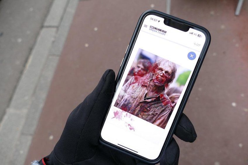 Une personne tenant un téléphone intelligent sur lequel est affichée une photo de zombie. 2