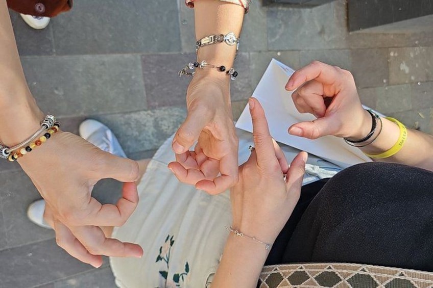 Mani che si stringono, si vedono braccialetti e un quaderno. 5