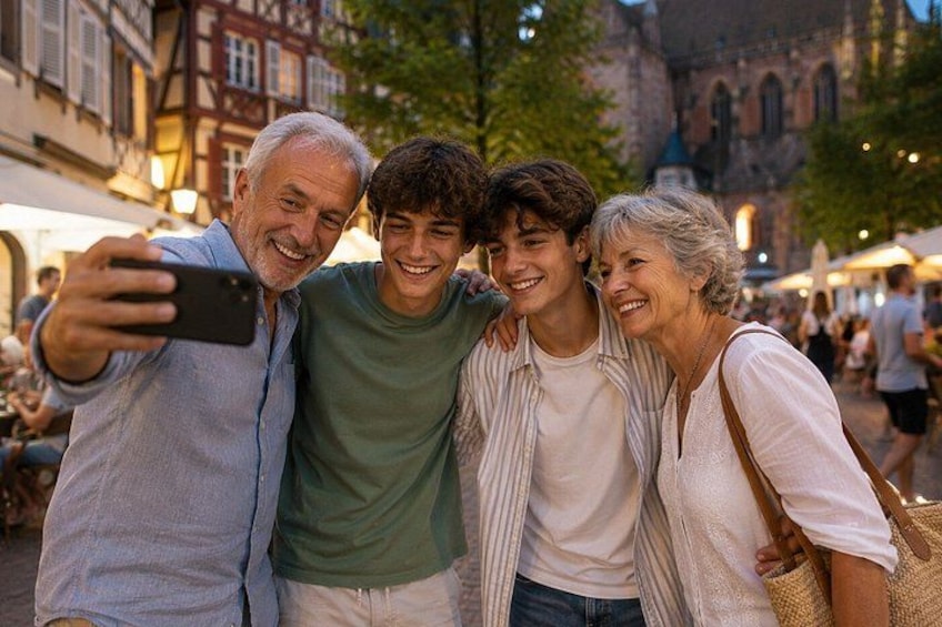 A group of people taking a selfie in a public square with historic buildings in the background. 1