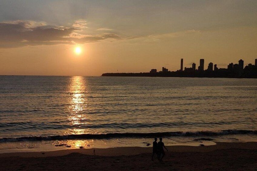 A sunset over a body of water with a city skyline in the background. 1