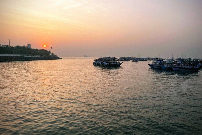 A sunset over a calm river with boats and a distant shoreline. 2