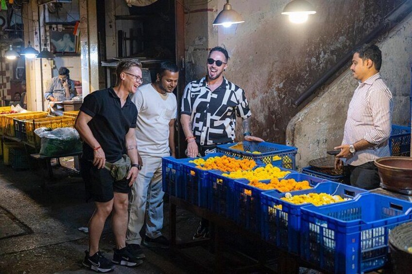 People standing around crates of oranges in a market setting. 1