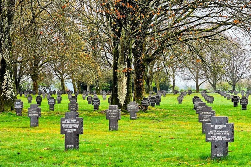 Un cimetière avec de nombreuses pierres tombales et un grand arbre au centre. 3