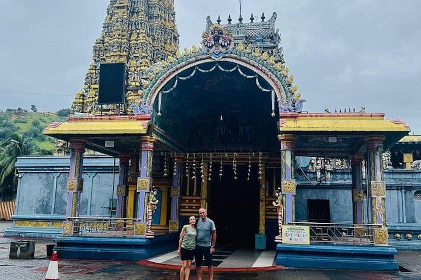 A temple entrance with a large, ornate archway and a tall, intricate tower in the background. 3