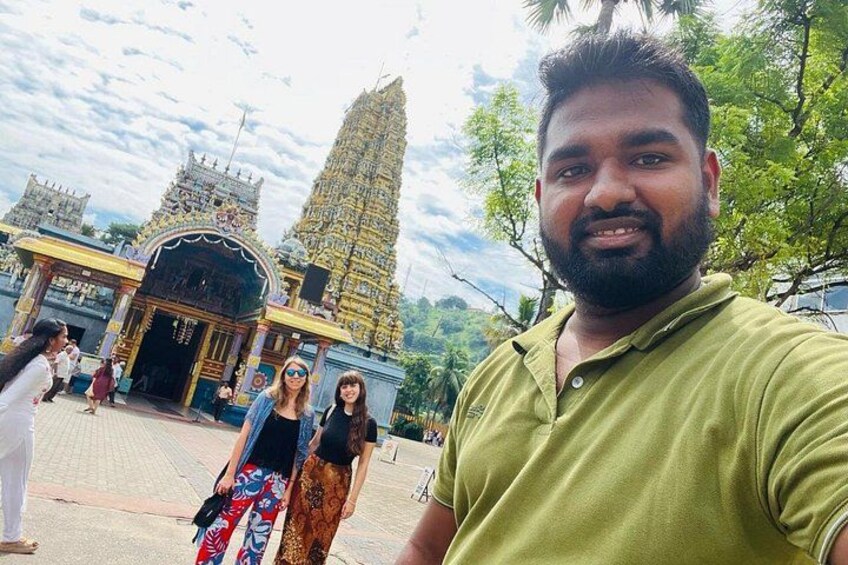 A temple with a tall spire, a person in a green shirt, and another person in a patterned skirt. 4