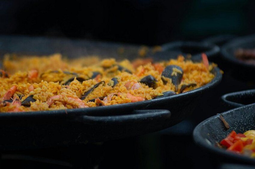 En närbild på en paella med skaldjur, innehållande ris, räkor, musslor och grönsaker. 4