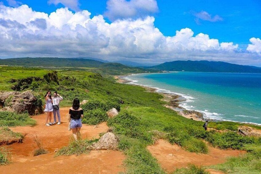 Un paisaje costero con un sendero de tierra, vegetación verde y vista al mar. 4