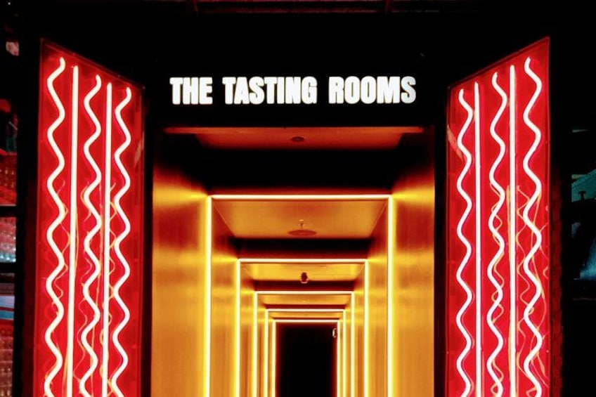 A neon-lit entrance with the sign 'THE TASTING ROOMS' and a corridor leading into darkness. 3