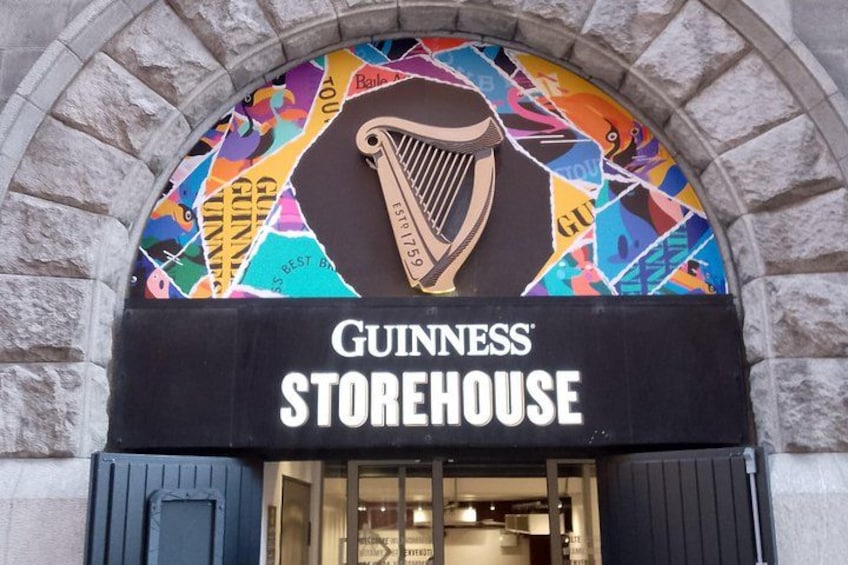 A Guiness Storehouse with a colorful mural and a harp logo. 5