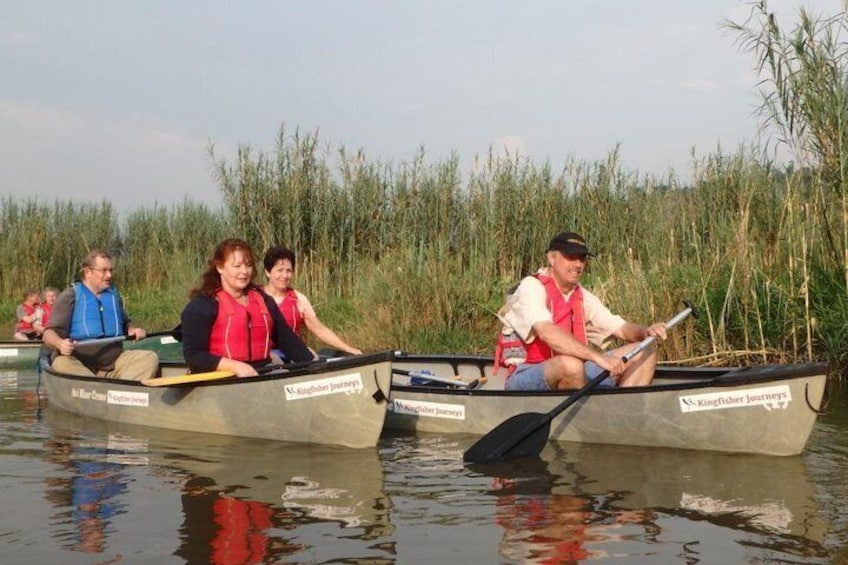 Due canoe su un fiume calmo, con canneti sullo sfondo. 1