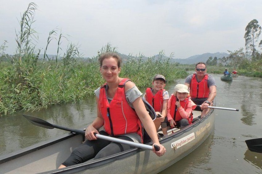 Un grupo de personas en una canoa en un río, usando chalecos salvavidas. 2
